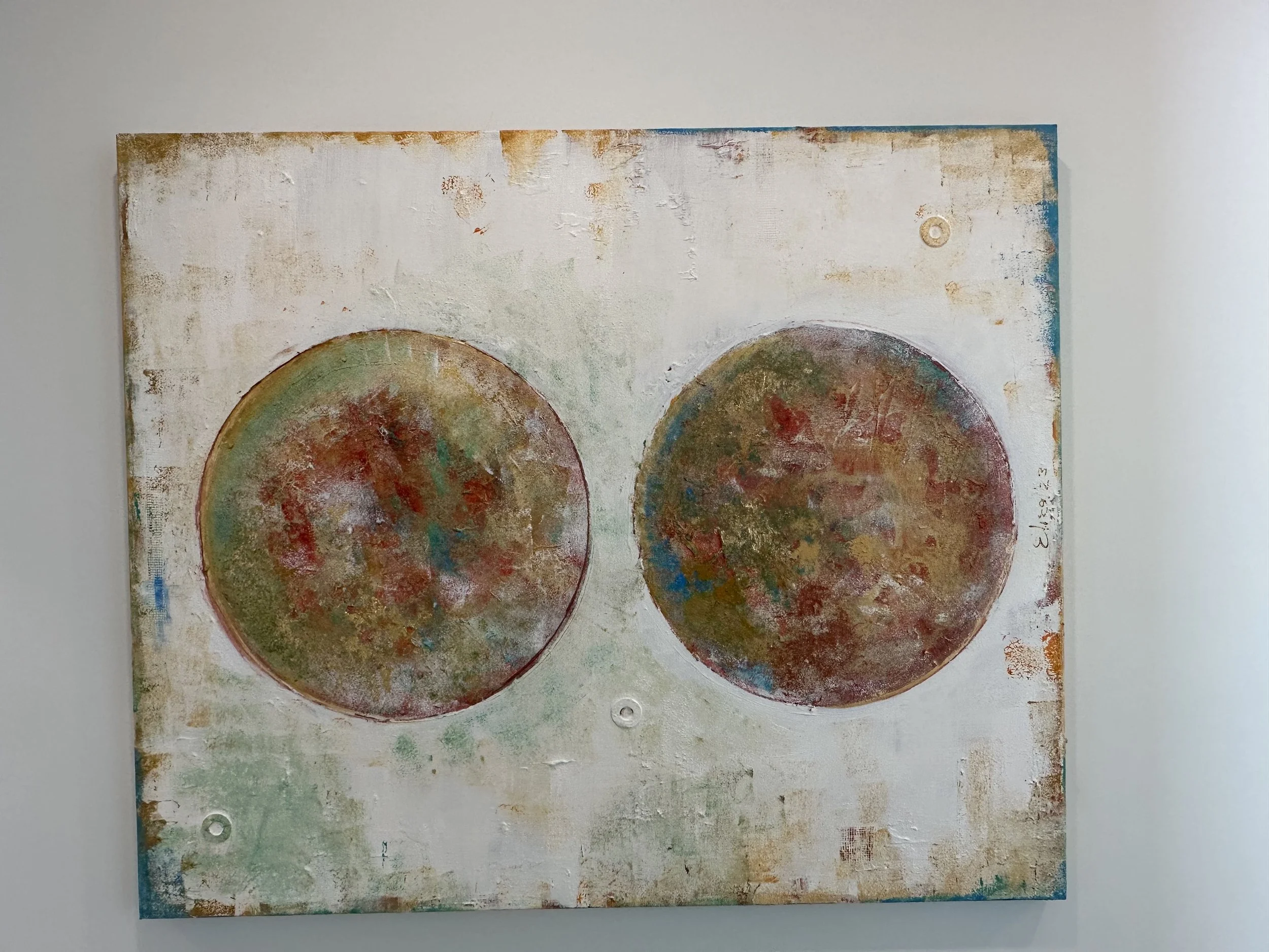 Abstract painting with two circular shapes on a textured background.