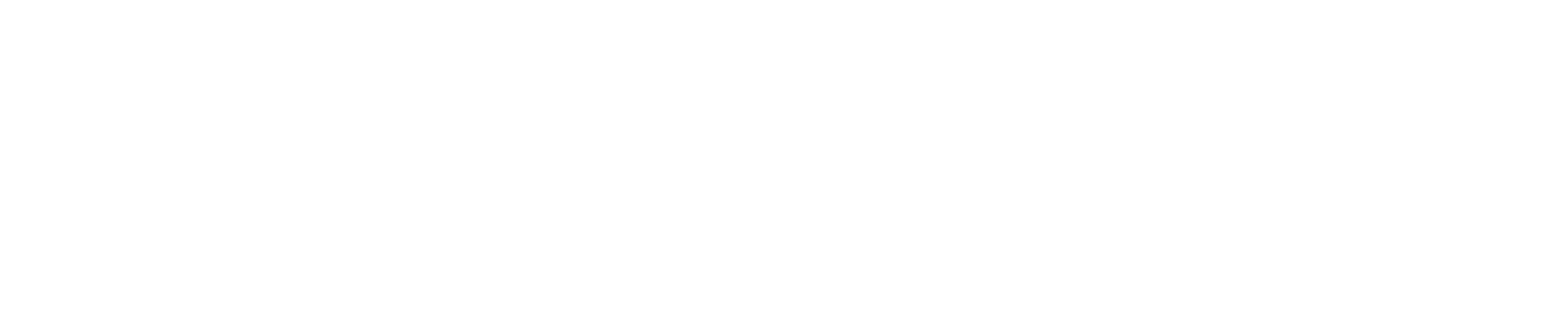 A clear glass of orange juice and a bowl of orange slices on a white surface.