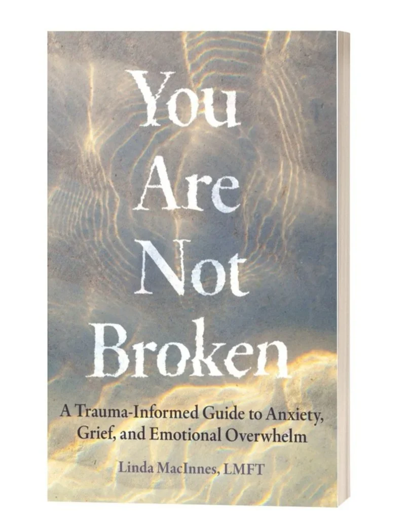 Book titled "You Are Not Broken" by Linda MacInnes, LMFT, with a sky and water background.