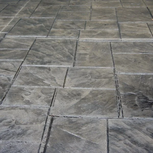 Close-up of a stone or concrete tiled floor with grout lines.