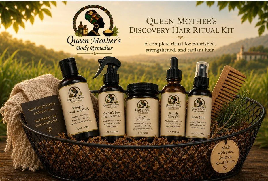 Queen Mother's Discovery Hair Ritual Kit containing five hair care products in a black wire basket with a wooden comb and a sprig of rosemary, set outdoors with a blurred natural landscape background.