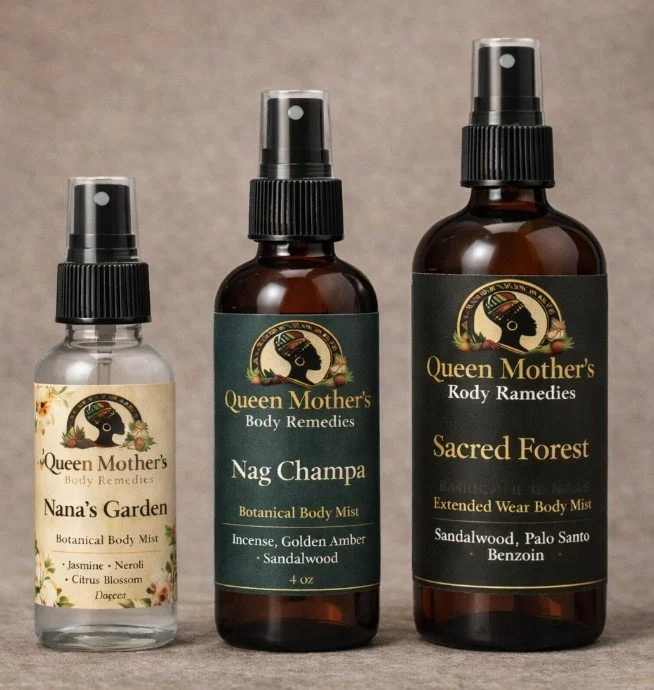 Three spray bottles of Queen Mother's Body Remedies mist, labeled 'Nana's Garden', 'Nag Champa', and 'Sacred Forest', arranged on a neutral background.