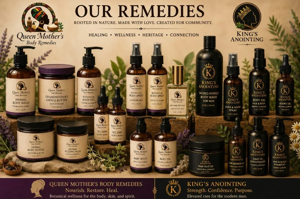 A collection of Queen Mother's Body Remedies and King's Anointing natural skincare and wellness products, including body wash, body butter, body gel, body spray, face serums, baby wash, hair and beard oils, hair butter, and hair and scalp conditioner, arranged on a rustic surface with greenery and lavender accents.
