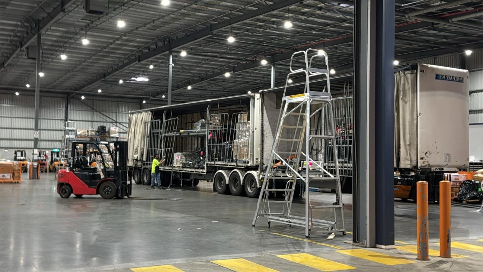 Inside a depot/warehouse with a partially-loaded semi-trailer.  Broadway express provides palletised freight haulage services throughout Australia.