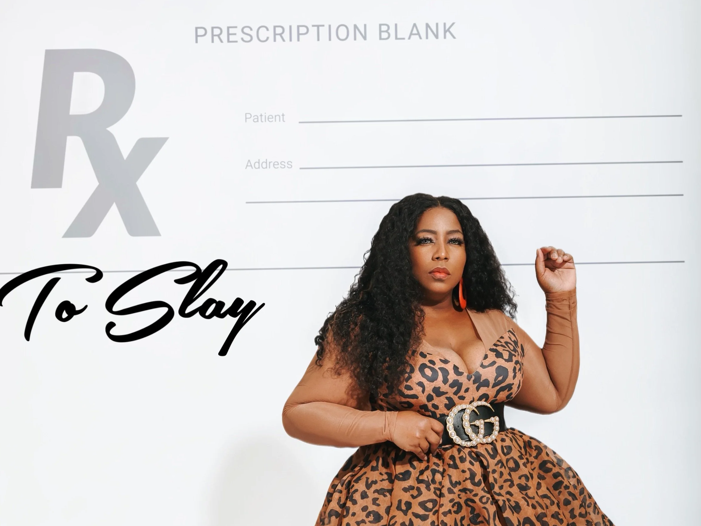 Woman in leopard print dress with long curly hair standing in front of prescription pad background, making a fist gesture.