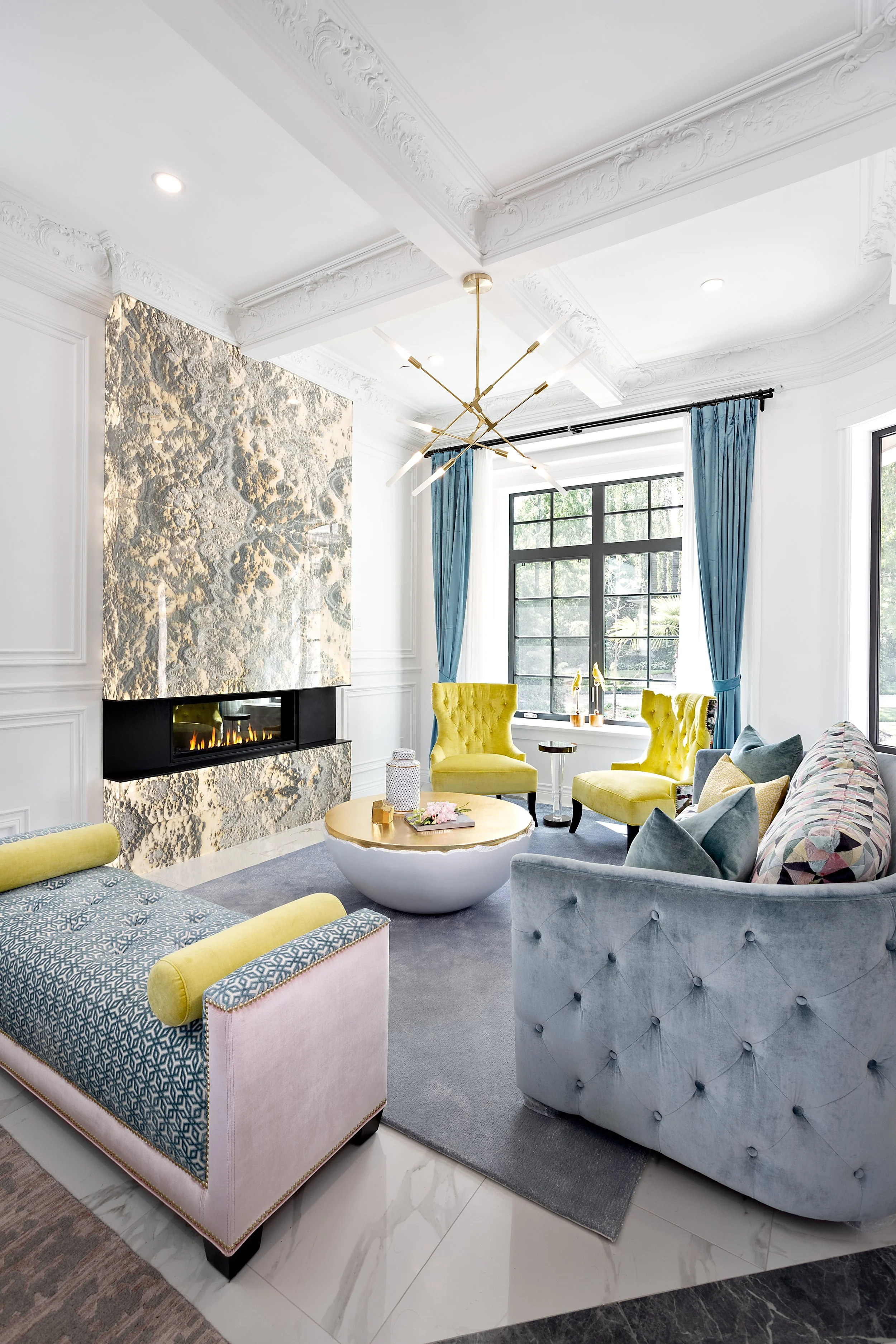 Bright and airy living space showcasing the blend of old architectural details with modern, colorful furniture and glamorous decor.