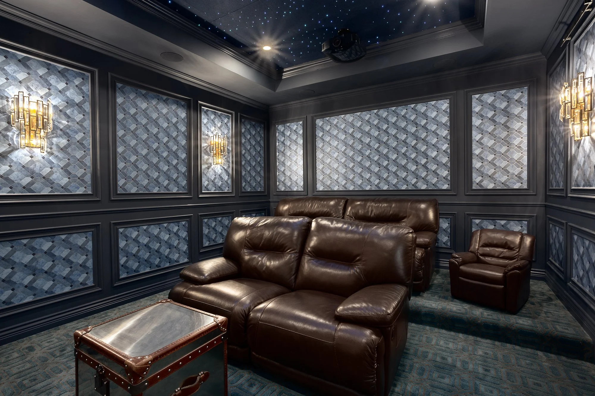 Dedicated luxury home theater with tiered leather seating and intricate textured wall panels, designed for high-end entertainment.