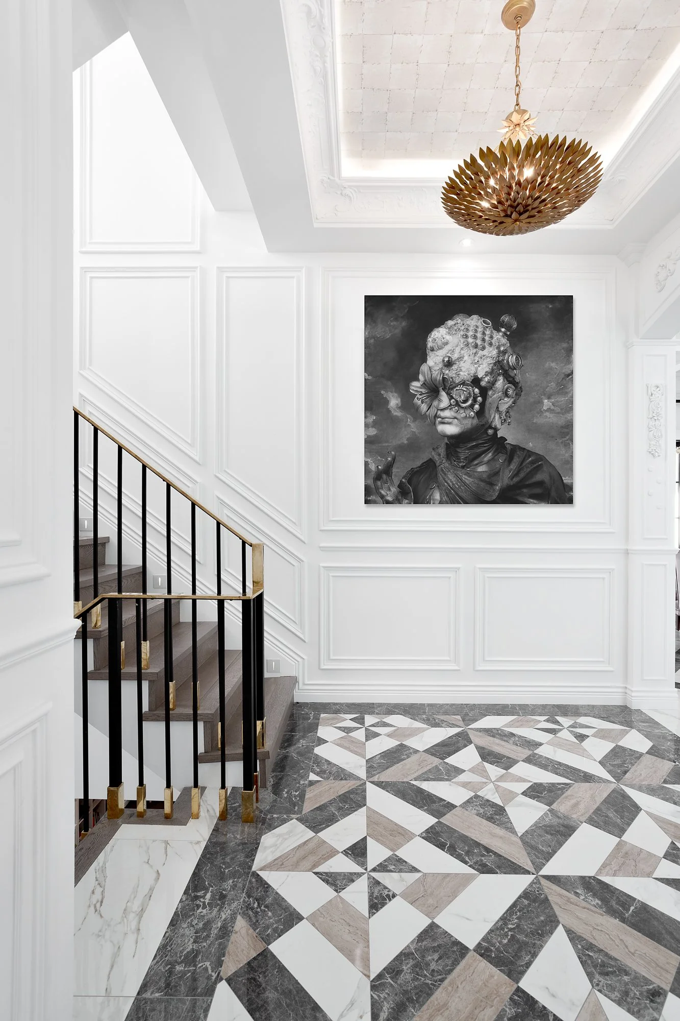 Sophisticated staircase area with black and gold railings, traditional white paneling, and a large monochromatic art piece.
