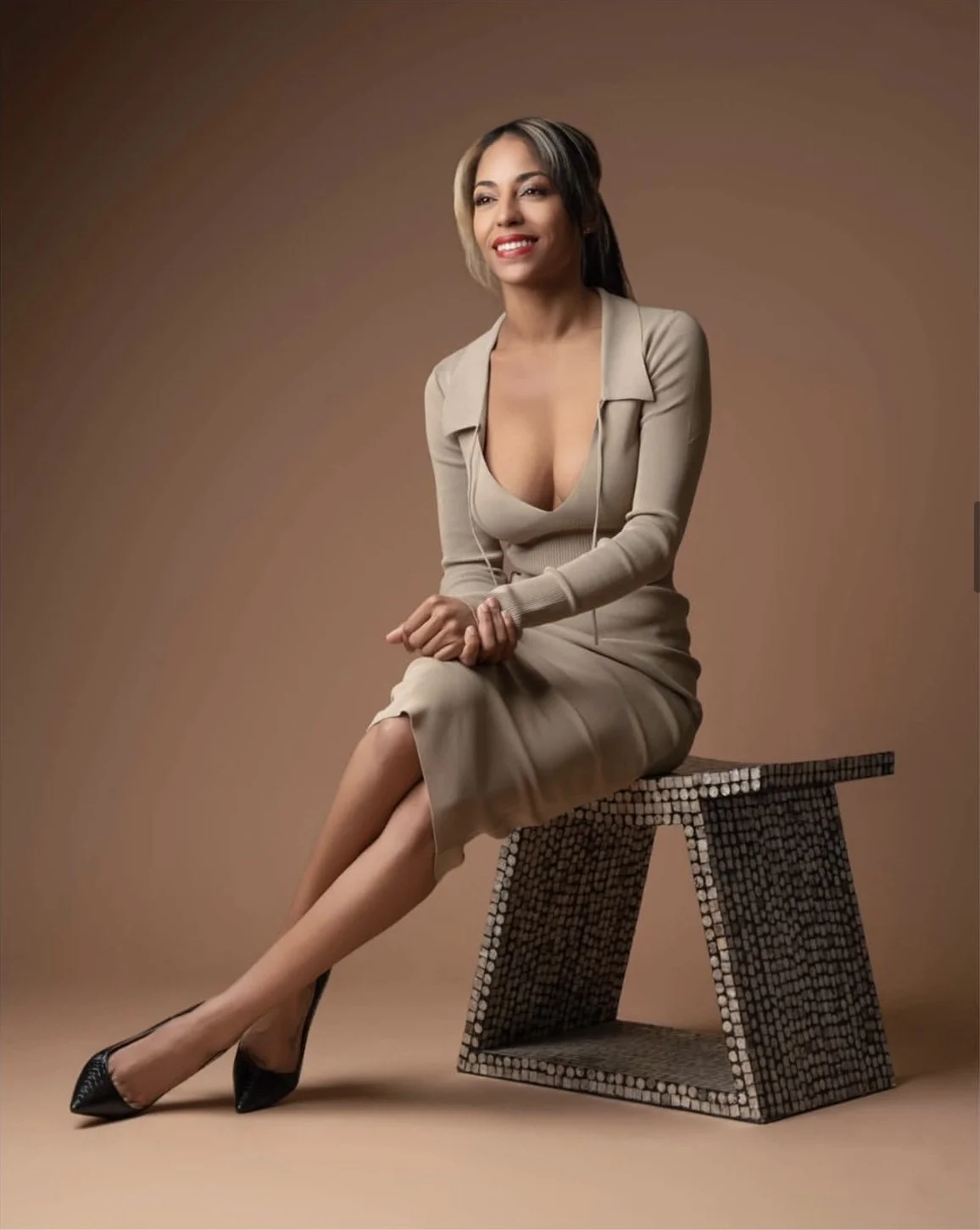 Coley in a beige House of CB set and black Louboutin heels, editorial fashion photo.