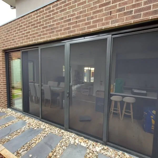Sliding glass doors leading into a modern home, with an interior dining area visible through the glass.
