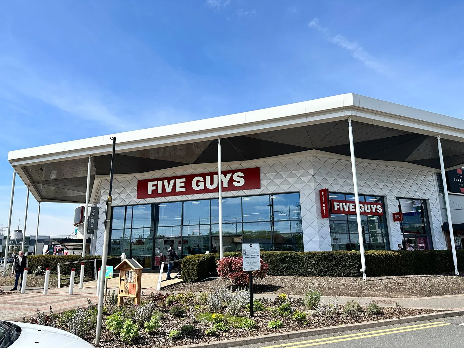 building with a sign called five guys with blue sky