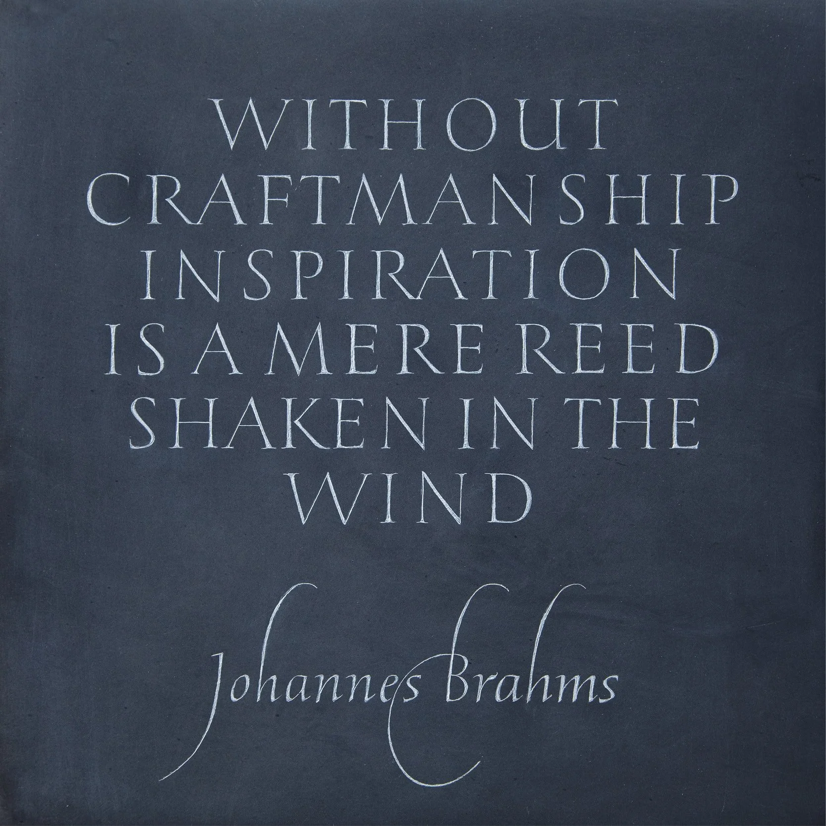 Close-up of a book cover with the quote, 'Without craftsmanship inspiration is a mere reed shaken in the wind,' by Johannes Brahms, written in elegant white calligraphy on a dark background.