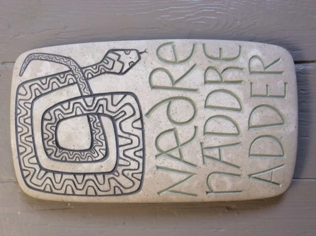 Stone sign with a carved snake and the text 'NAPA REED HIDDARD'