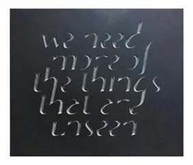 A chalkboard with the phrase 'We need more of the things we had or used' written in stylized cursive handwriting.