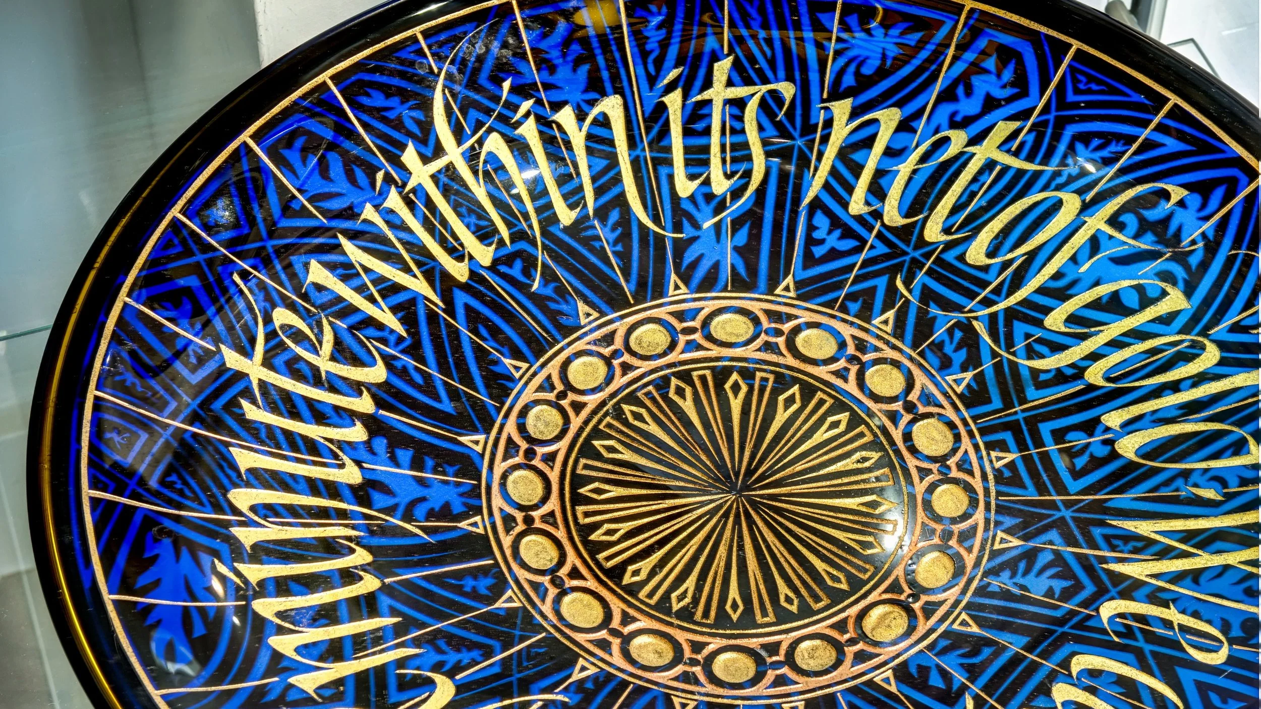 Close-up of a decorative, circular design with gold and blue intricate patterns and numbers.