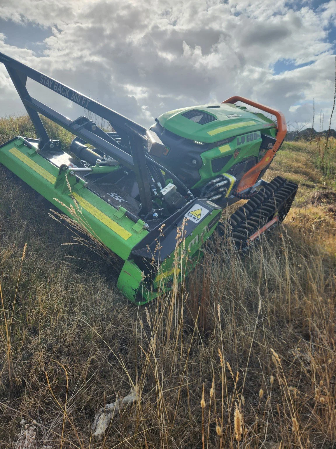 Remote-controlled slope mower clearing roadside vegetation for council fire mitigation in Great Southern WA