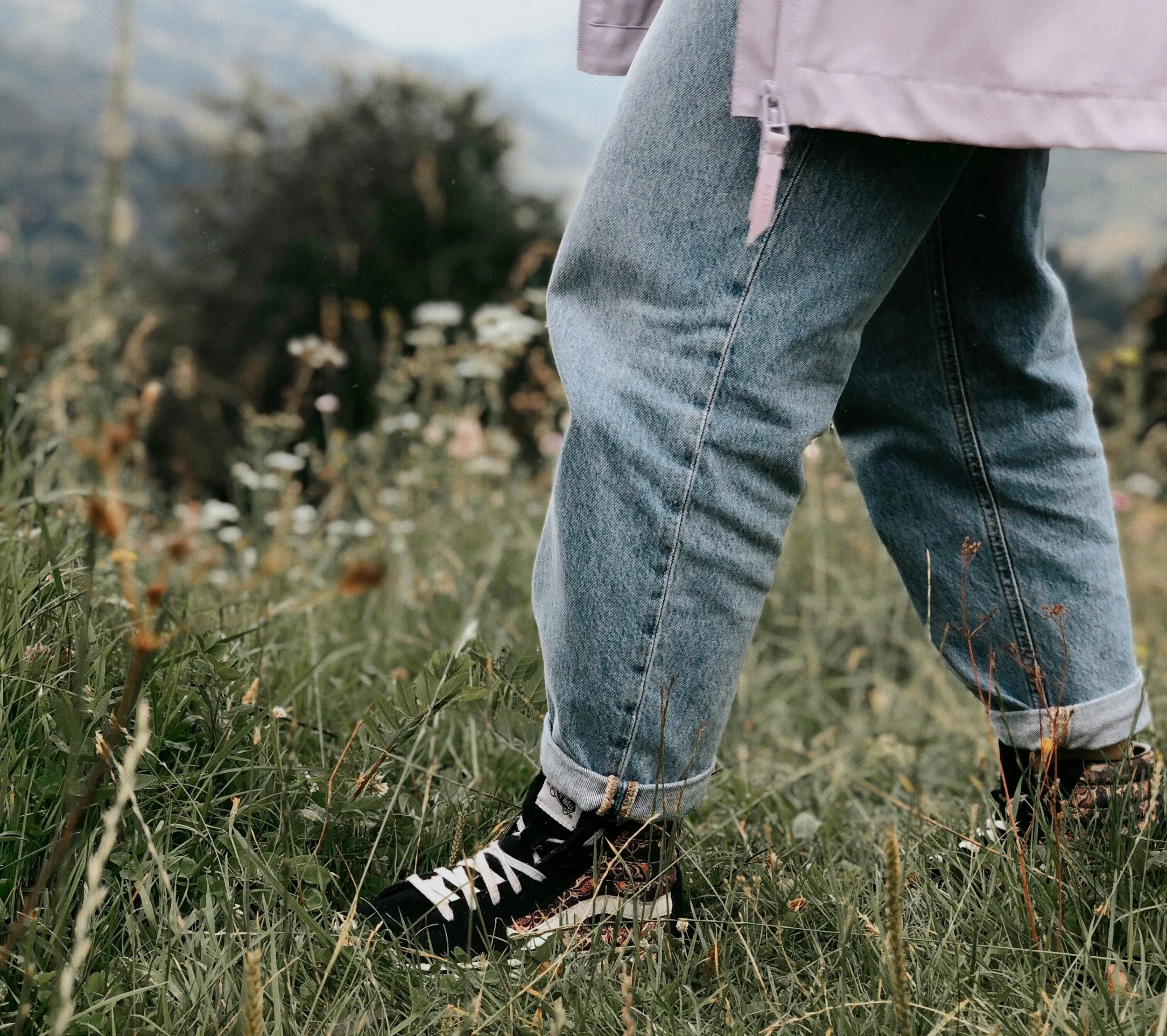 woman's legs wearing jeans in a grass field