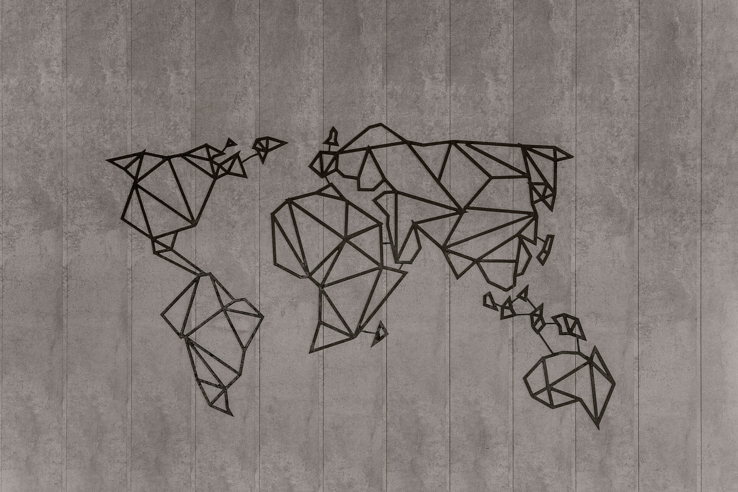 A wall-mounted art piece of a world map made from geometric black lines on a gray textured wall.