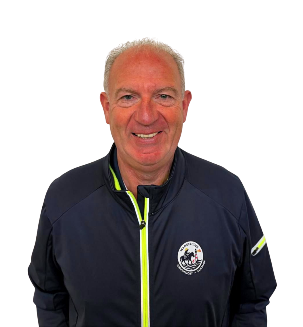 Een lachende man met kort grijs haar draagt een zwarte sportjas met een logo van een wandelclub.