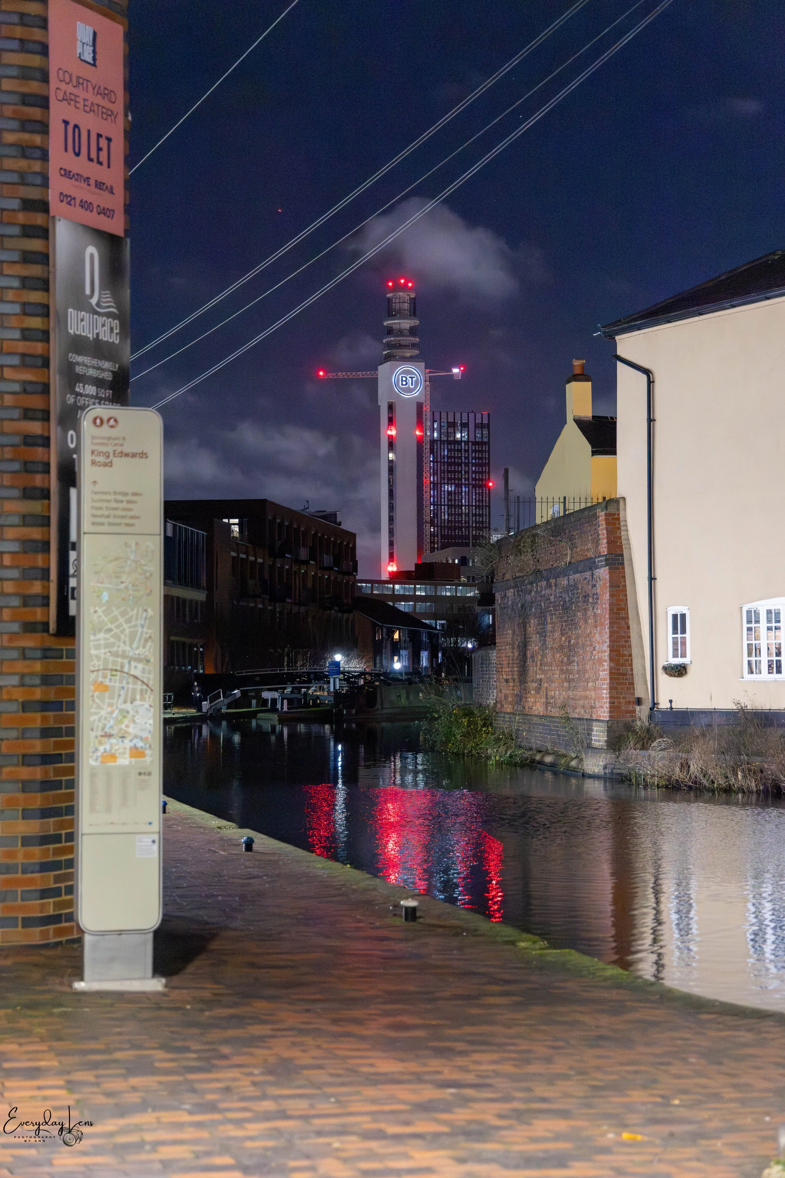 Red lights glowing over the canal at night