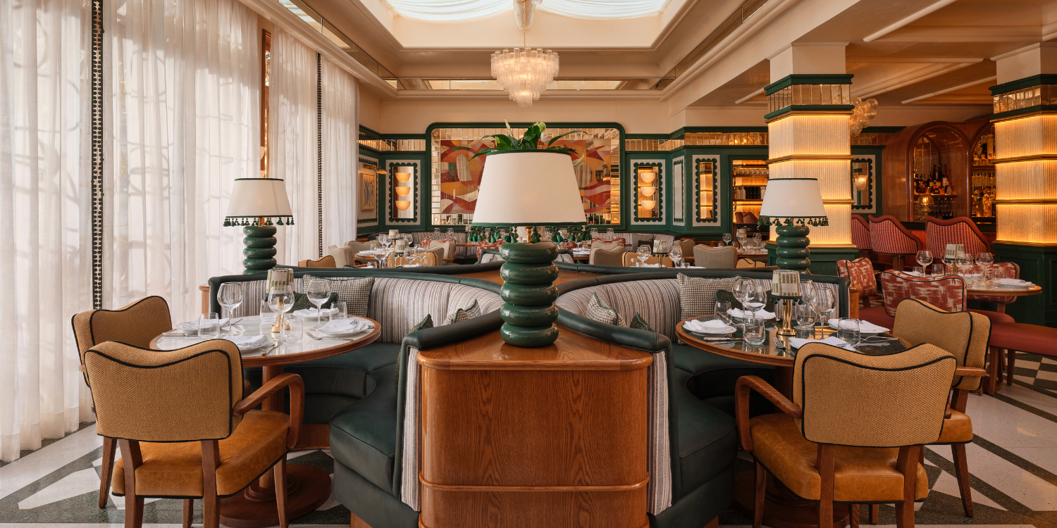 Salle à manger élégante avec des tables rondes, des lampes vertes et blanches, et un éclairage chaud, décorée de manière sophistiquée.