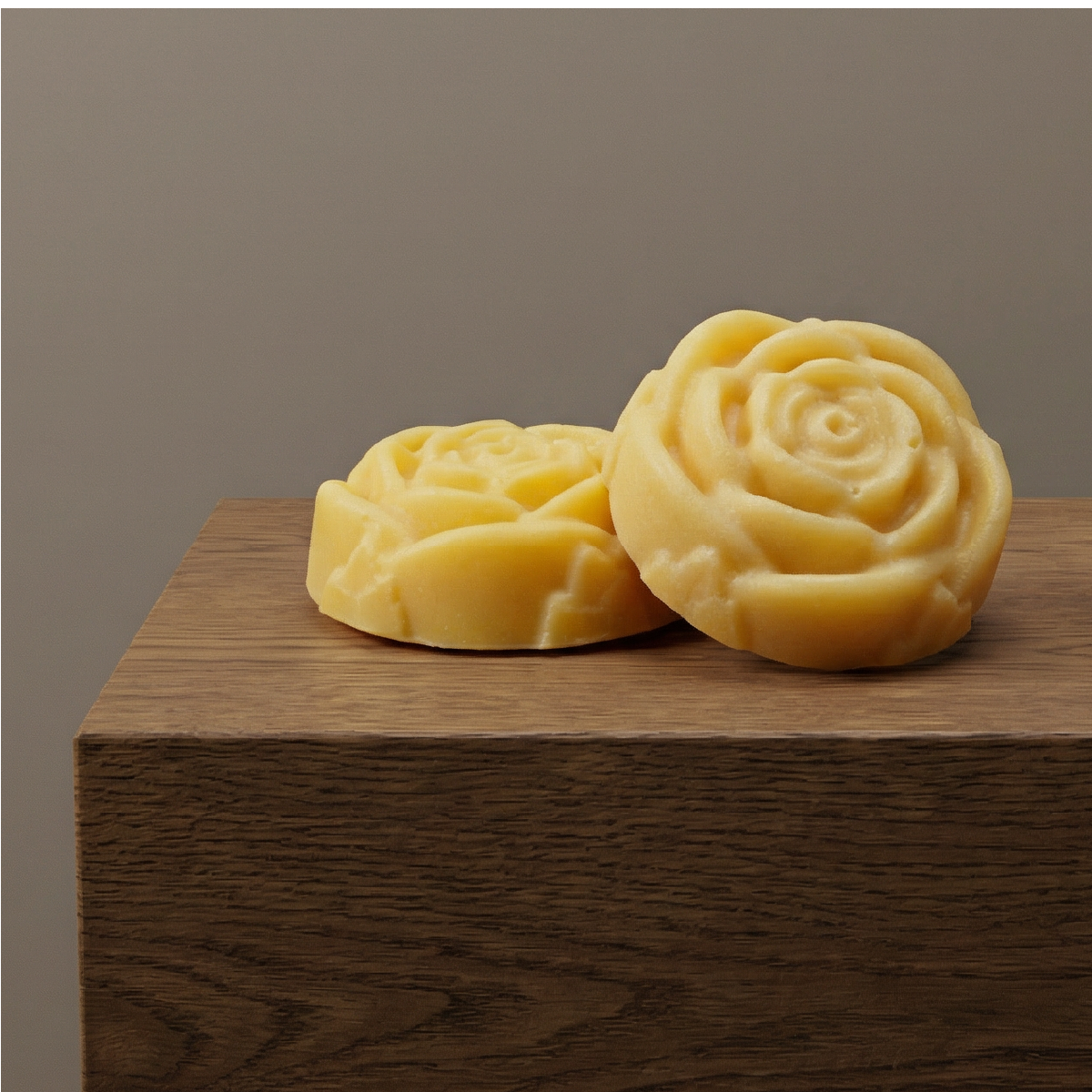 Two rose shaped soap bars on a brown counter