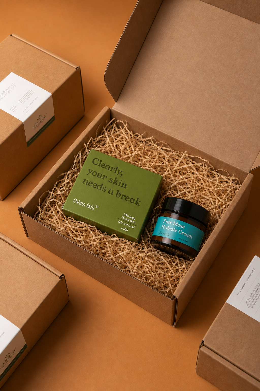 Overhead shot of an open kraft gift box containing Moringa Soap Box and Pure Moss Hydrate Cream.png