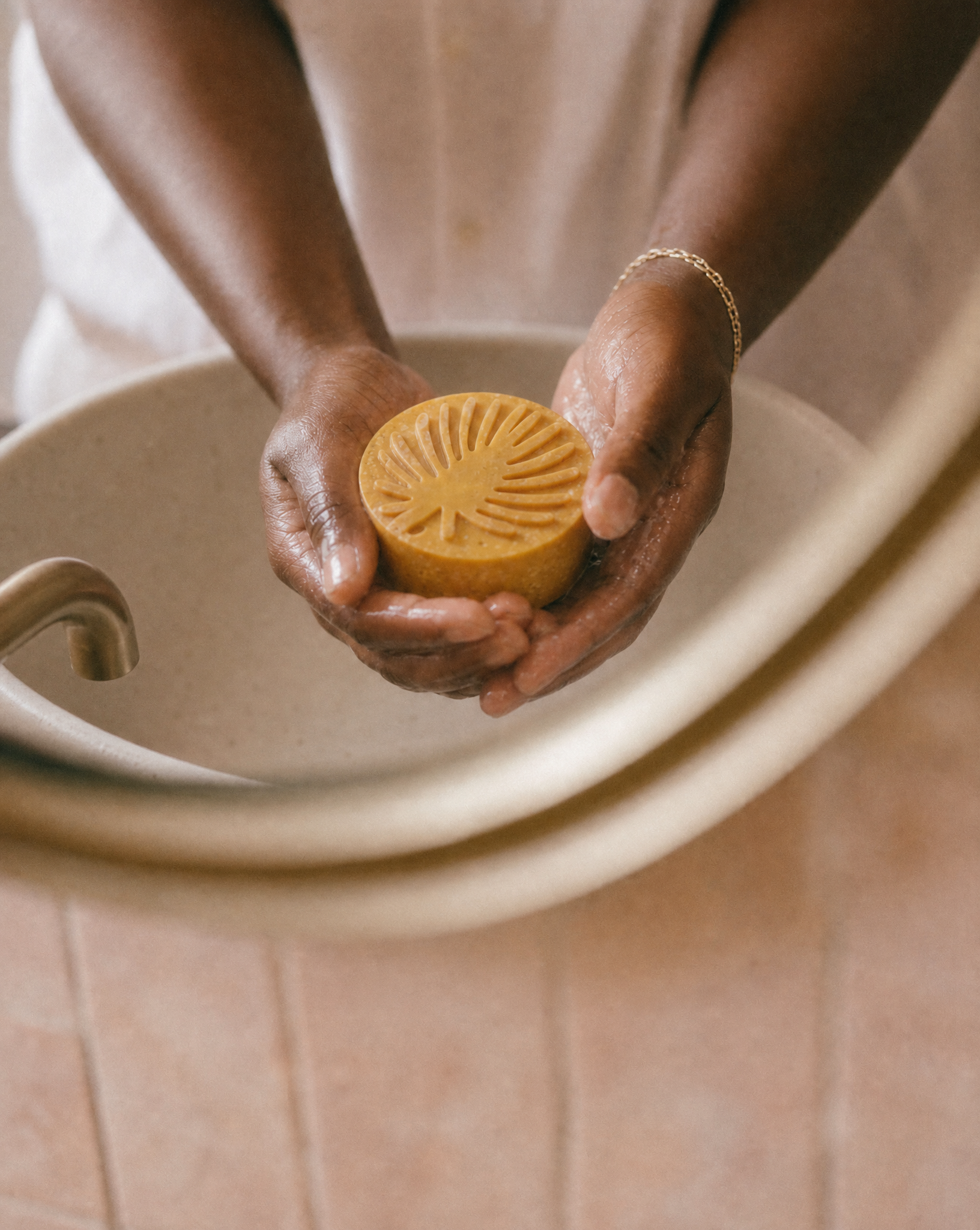Turmeric Sea Moss Facial bar lathering in hands mirror reflection.png