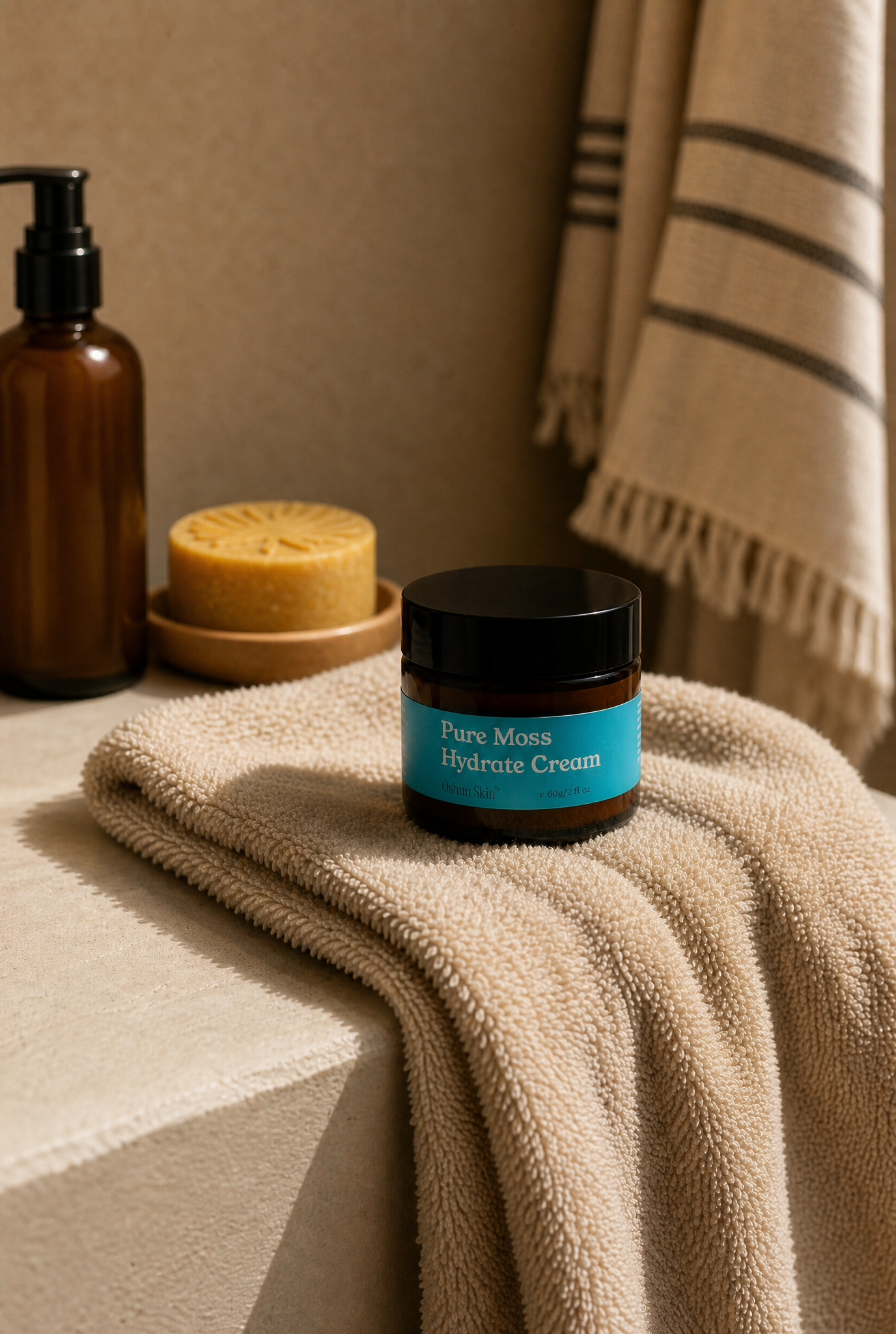 Sea Moss moisturiser jar sitting on a thick softly draped towel in a lived in bathroom, Turmeric facial bar on a soap dish in the background.png