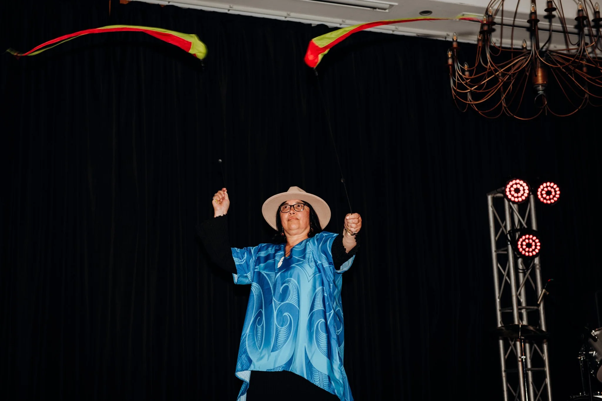 Keri Elvin performing with long poi streaming red and yellow tails.