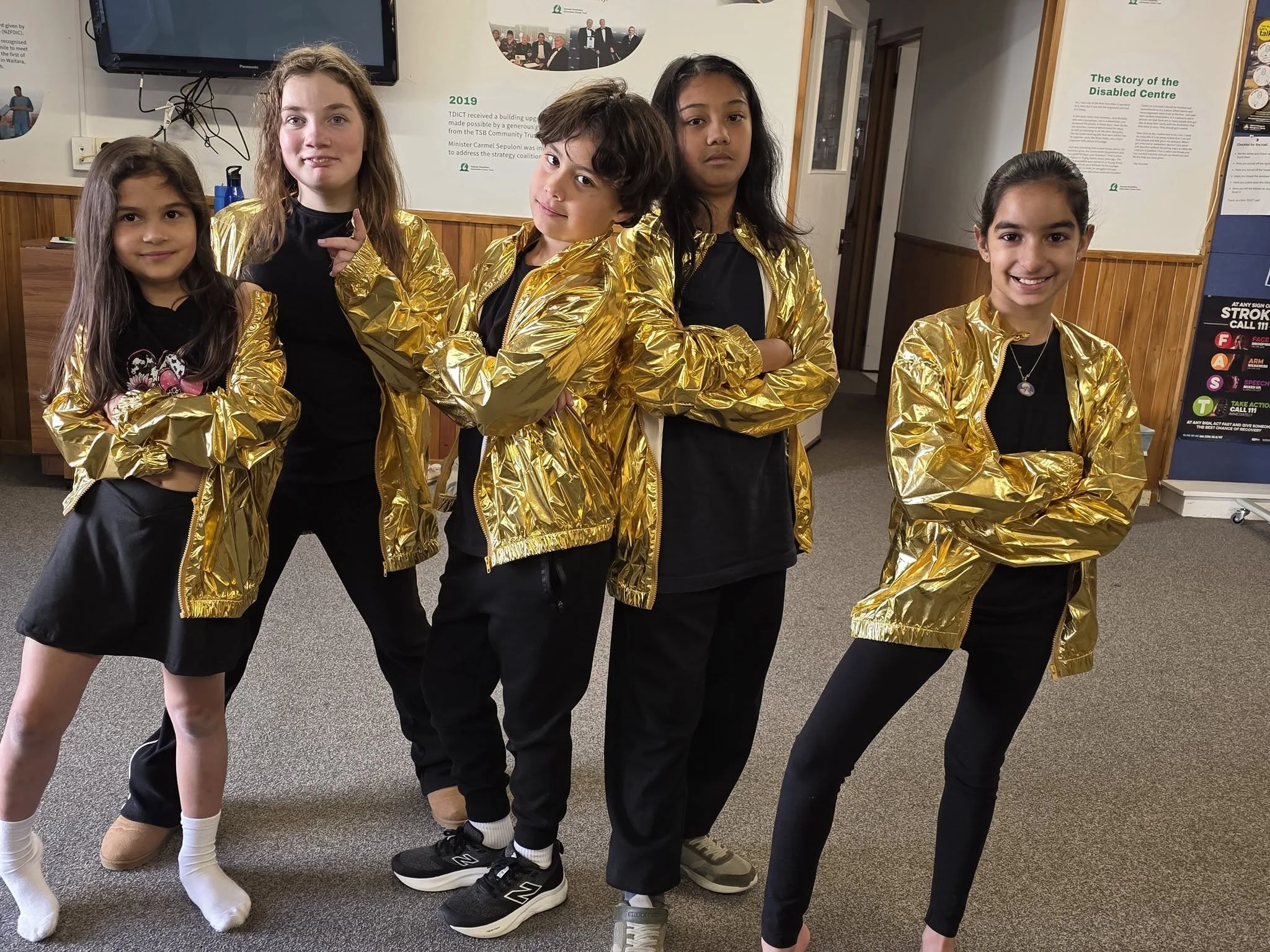 The PAC Troupe poses in their gold coats