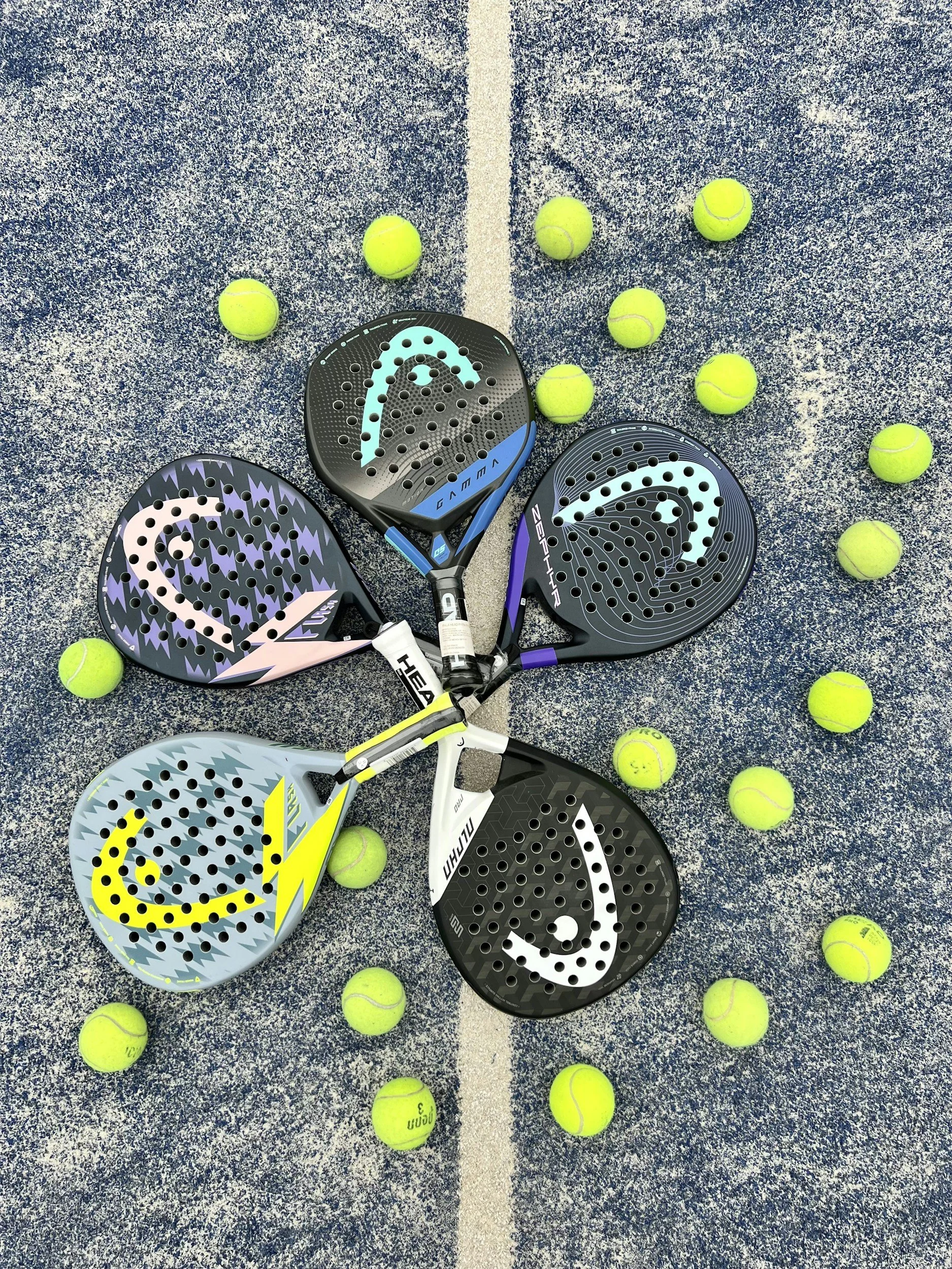 Five padel rackets arranged in a fan shape on a blue padel court, with padel balls scattered around them.