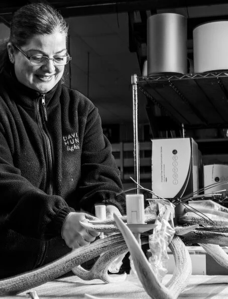 A woman working with a large octopus in a laboratory or workspace, smiling while handling the octopus.