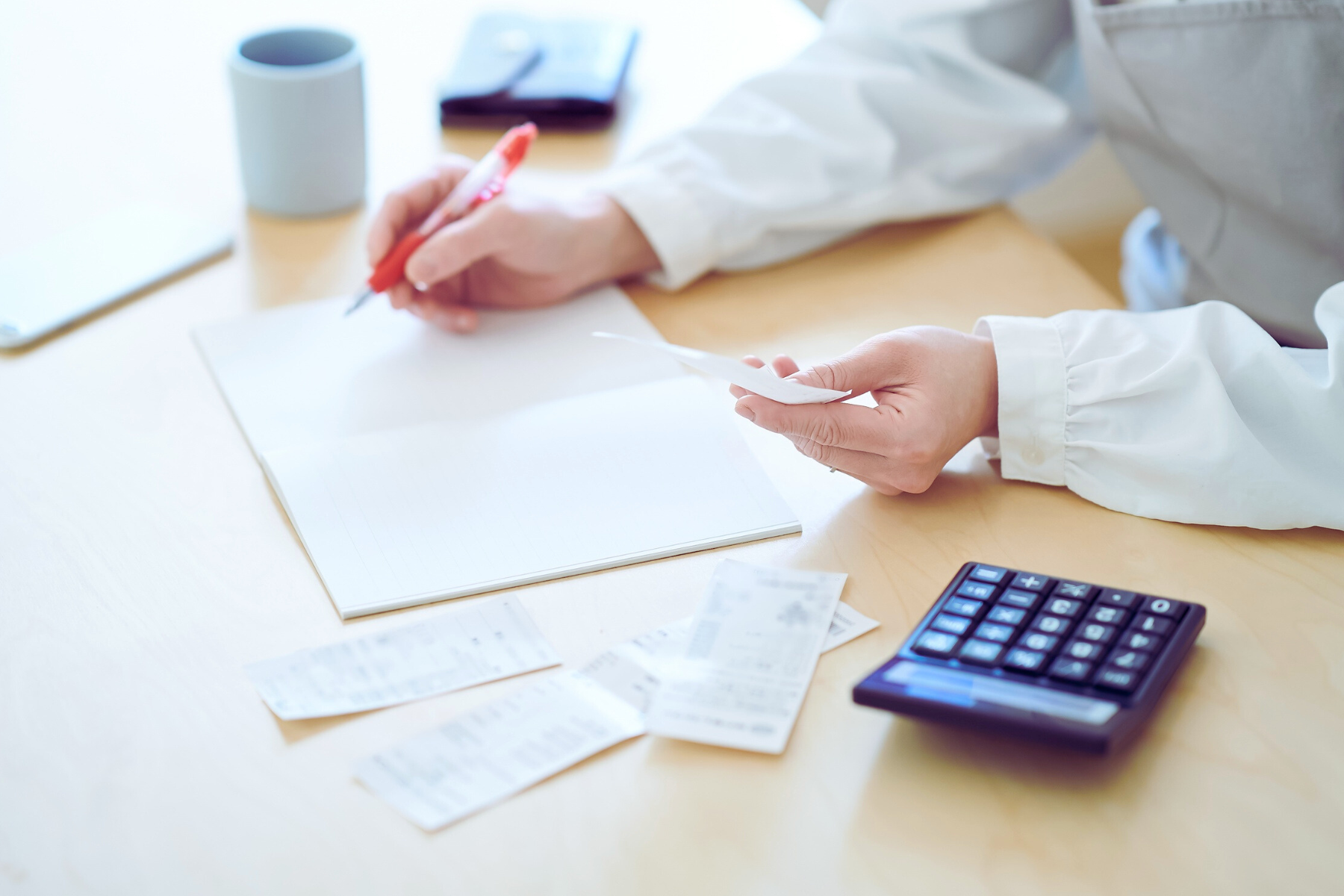 Person organizing receipts and making notes.