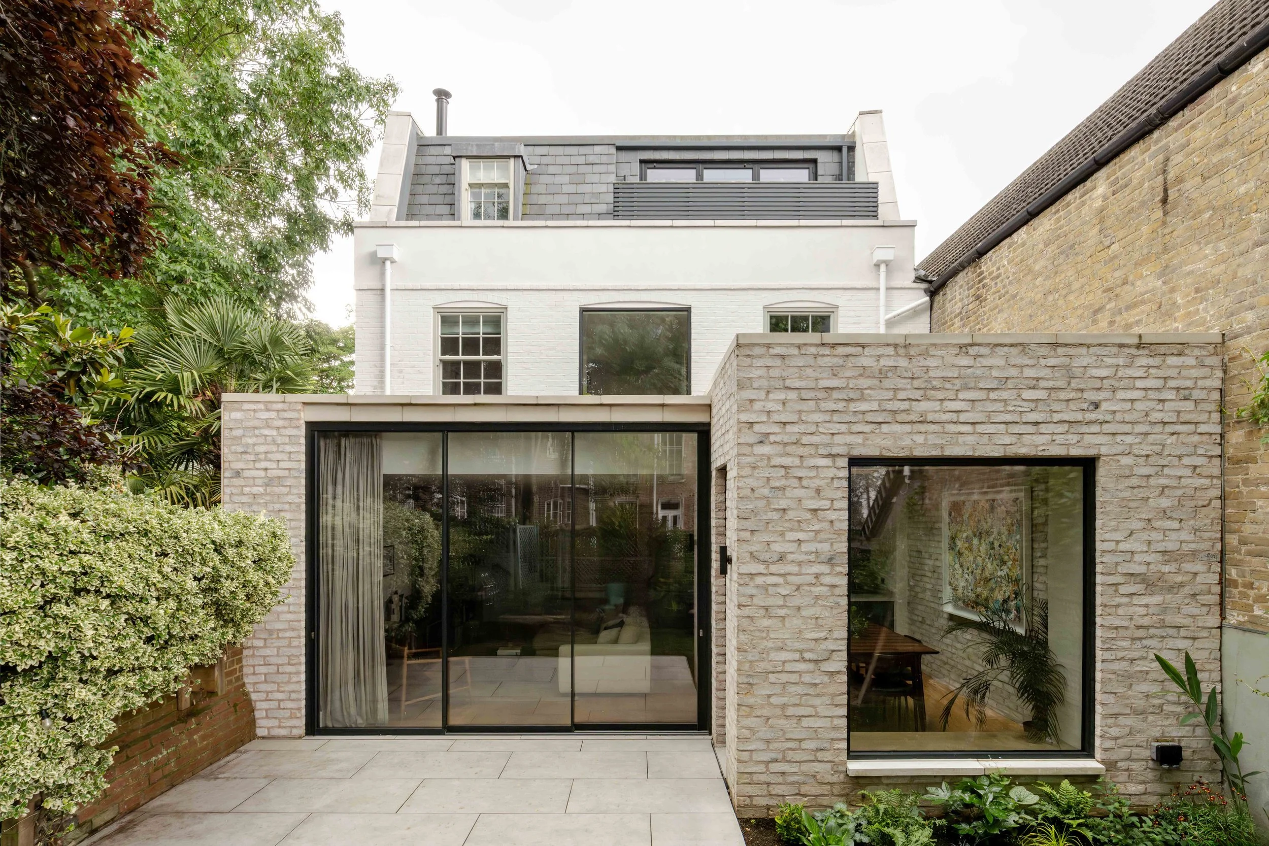 Detached mews house in Camberwell conservation area with mansard roof extension in slate and contemporary rear extension in pale buff brickwork - MarshKeene
