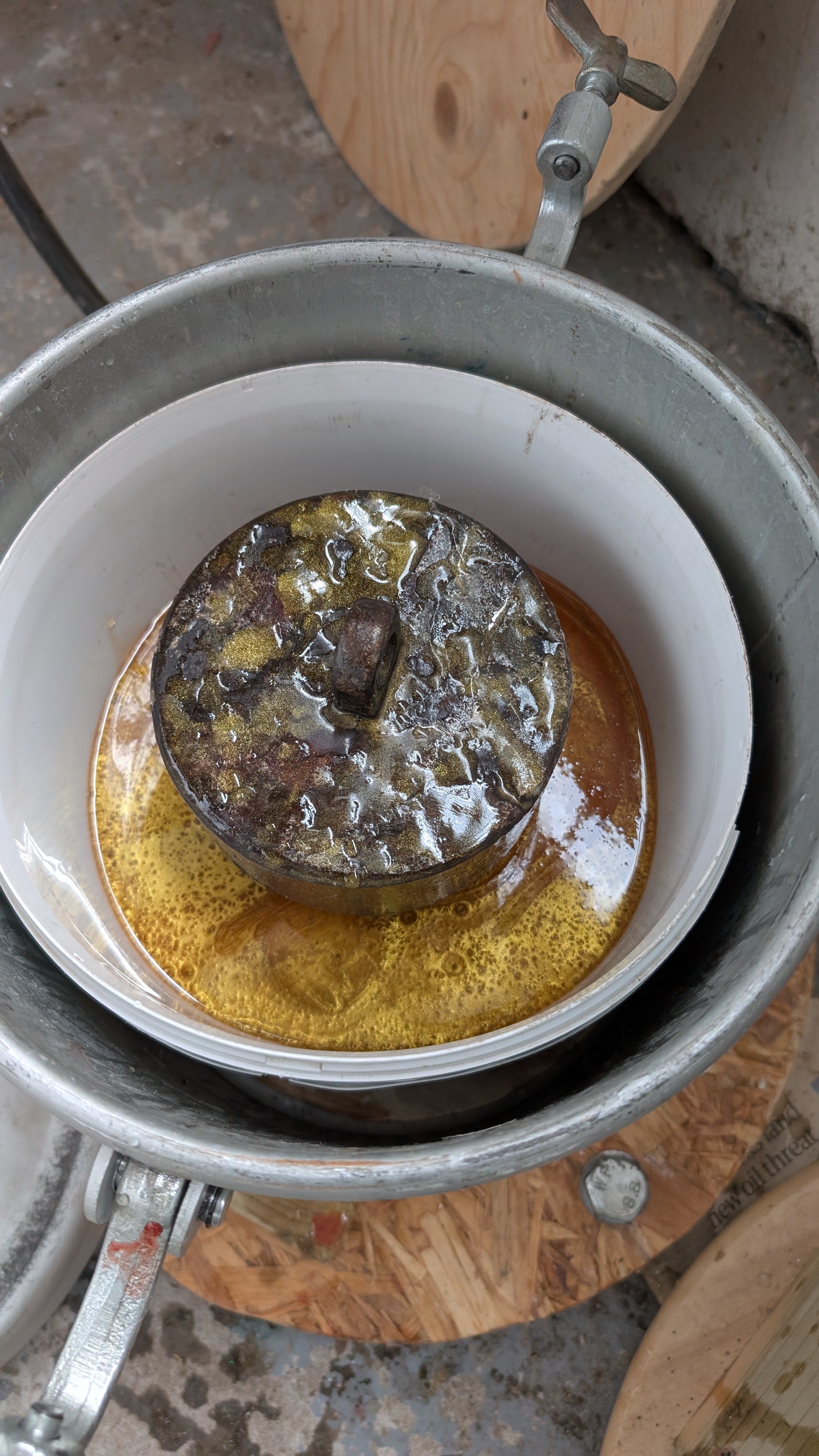 The bucket with resin added and a heavy weight to stop the blank floating.