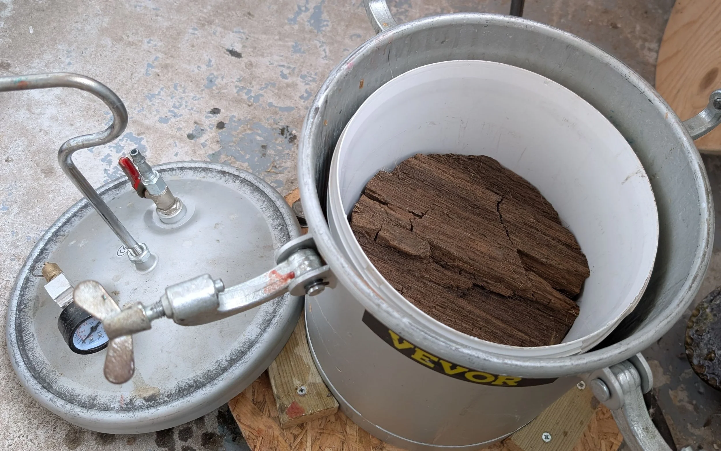 The rough blank is placed in a bucket, inside this pressure tank. The resin is poured, the lid secured and pressurised to 60psi for 24 hours. This forces resin into every crevice and eliminates air bubbles.