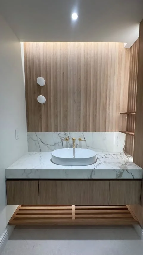 Renovated bathroom with wood-paneled accent wall in Cresskill, NJ home by EC Construction & Management