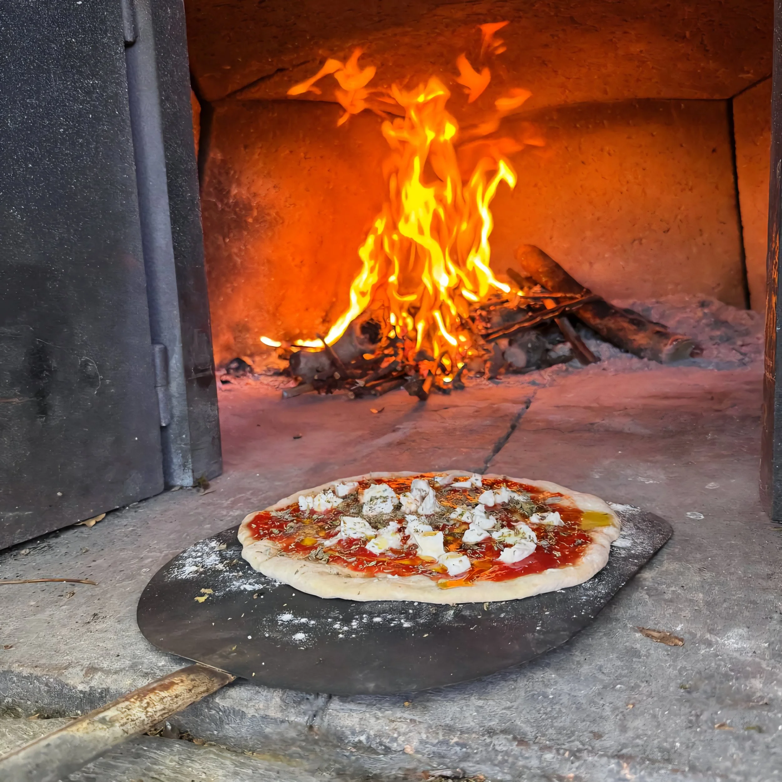 Pizza baking in a wood-fired oven with flames in the background.