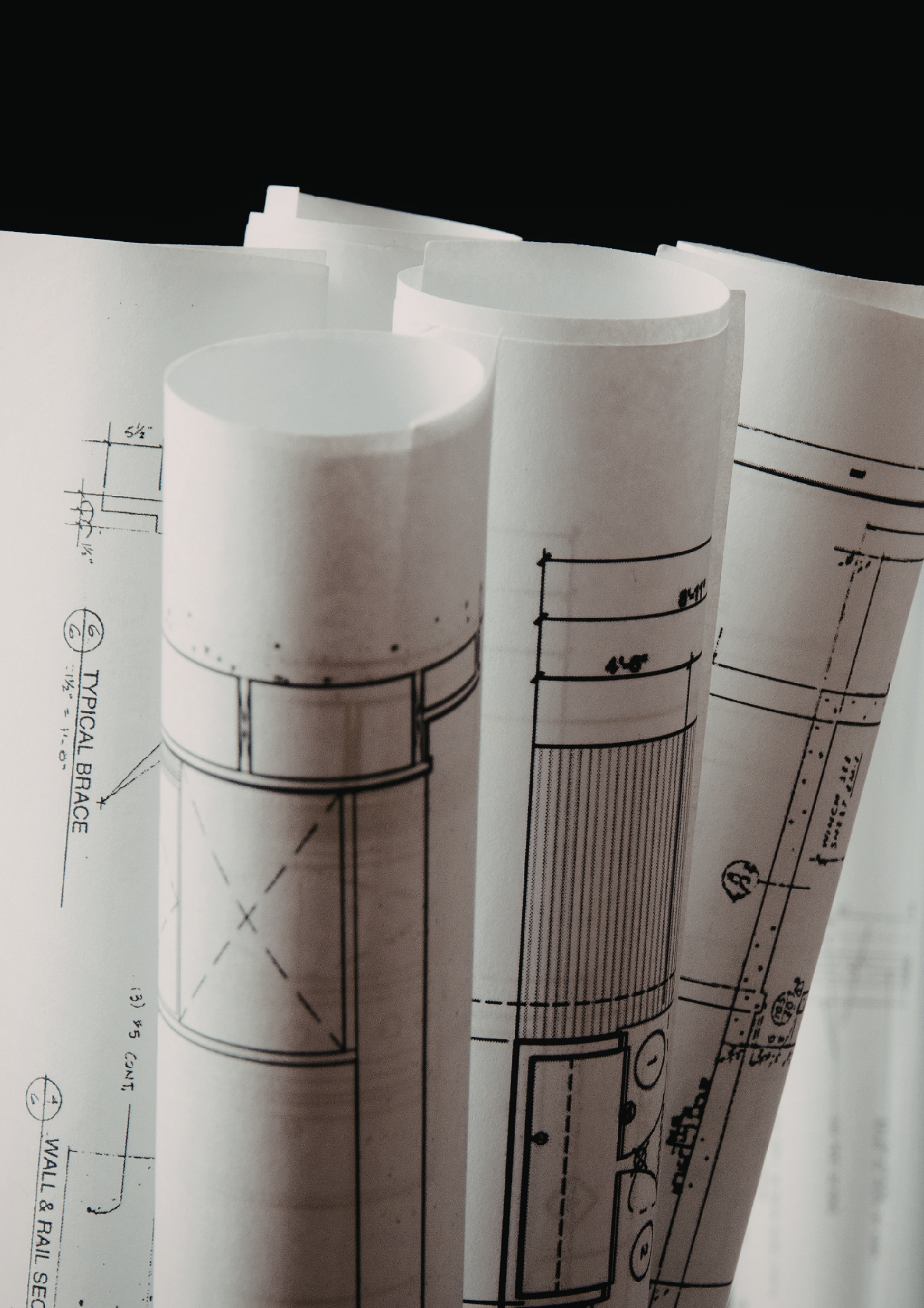 Several rolled-up blueprints with technical drawings and measurements.