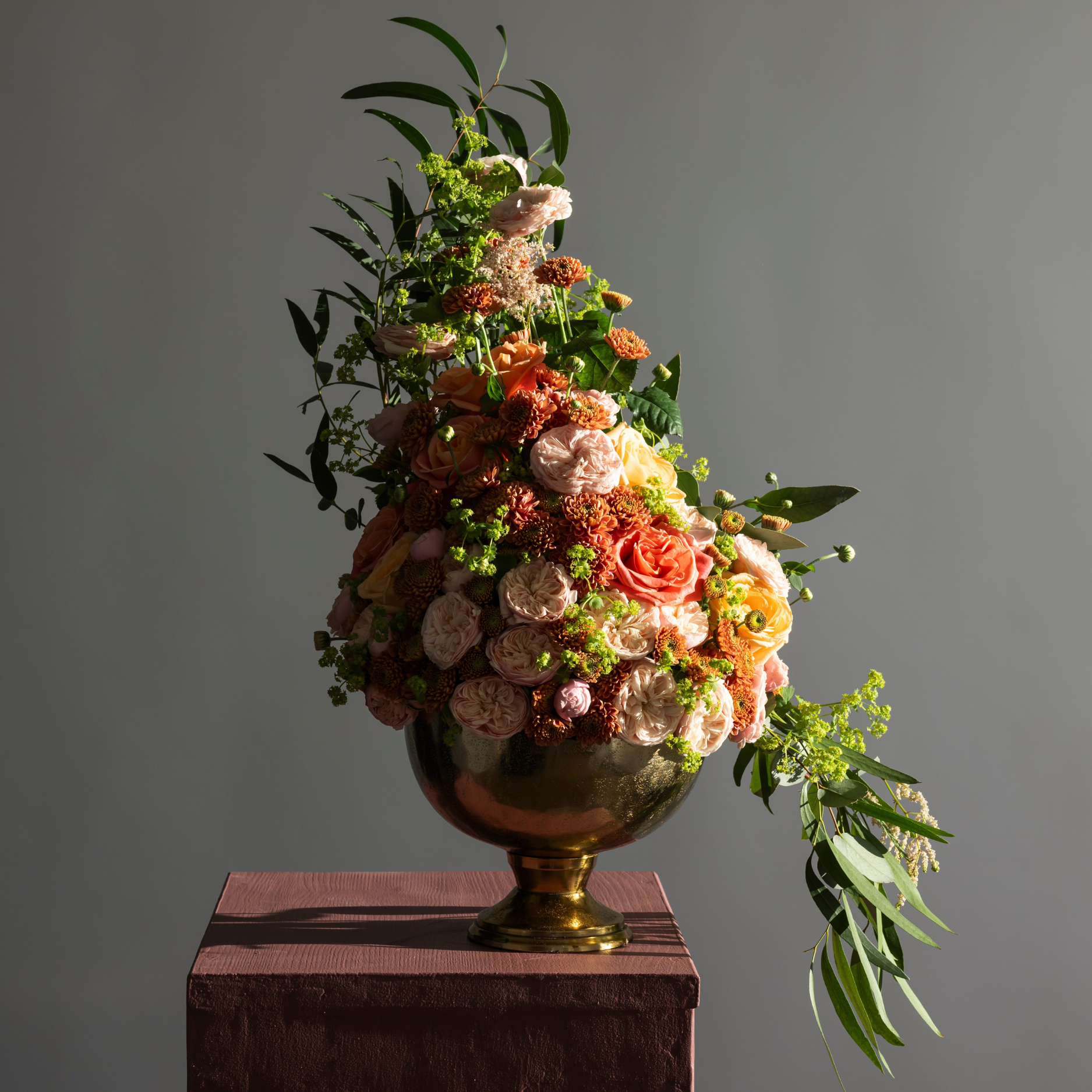 flowers in a pedestal arrangement using pink spray roses and peach roses