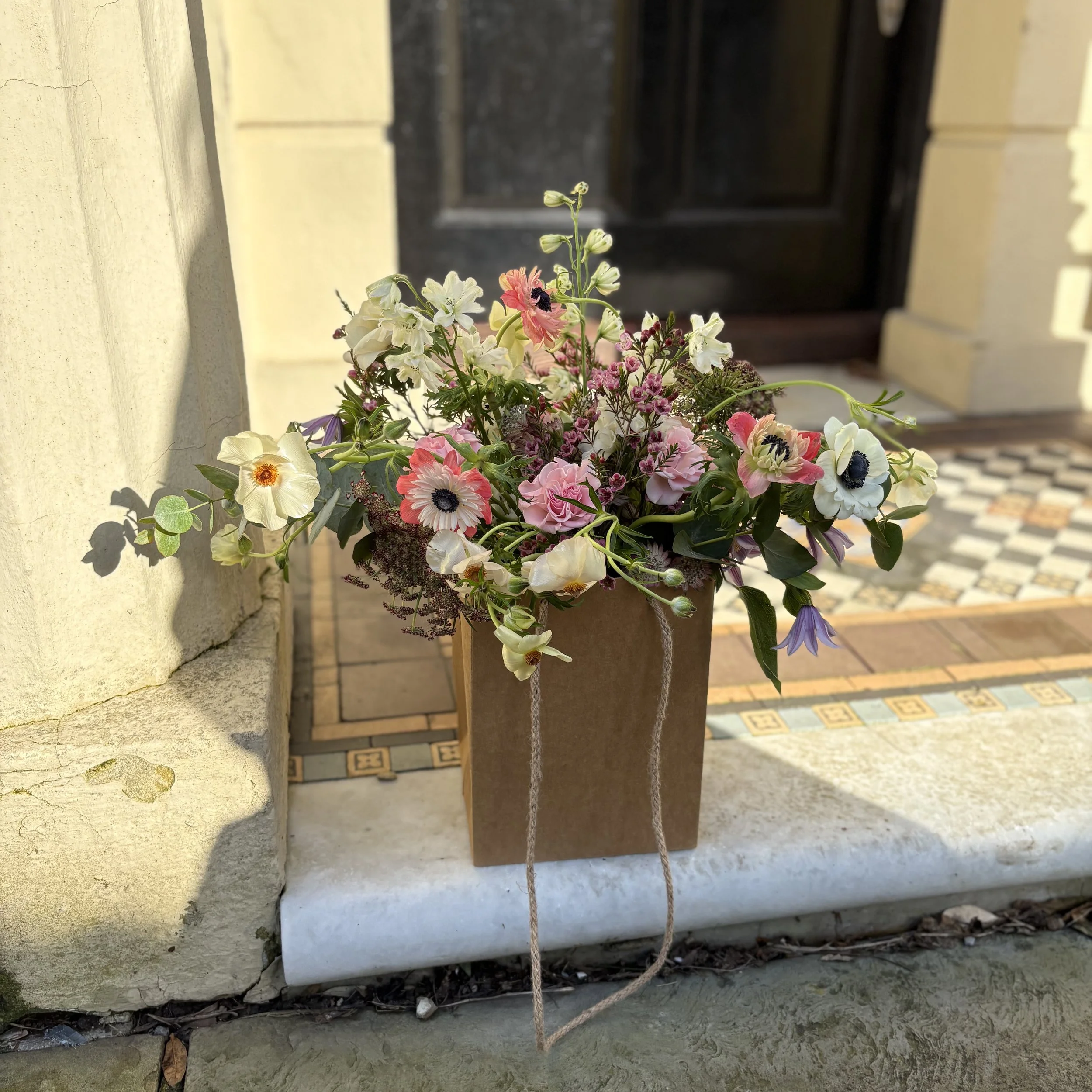 a_bouquet_of_flowers_in_a_gift_bag_being_delivered_to_a_door_in_Lewes.jpg