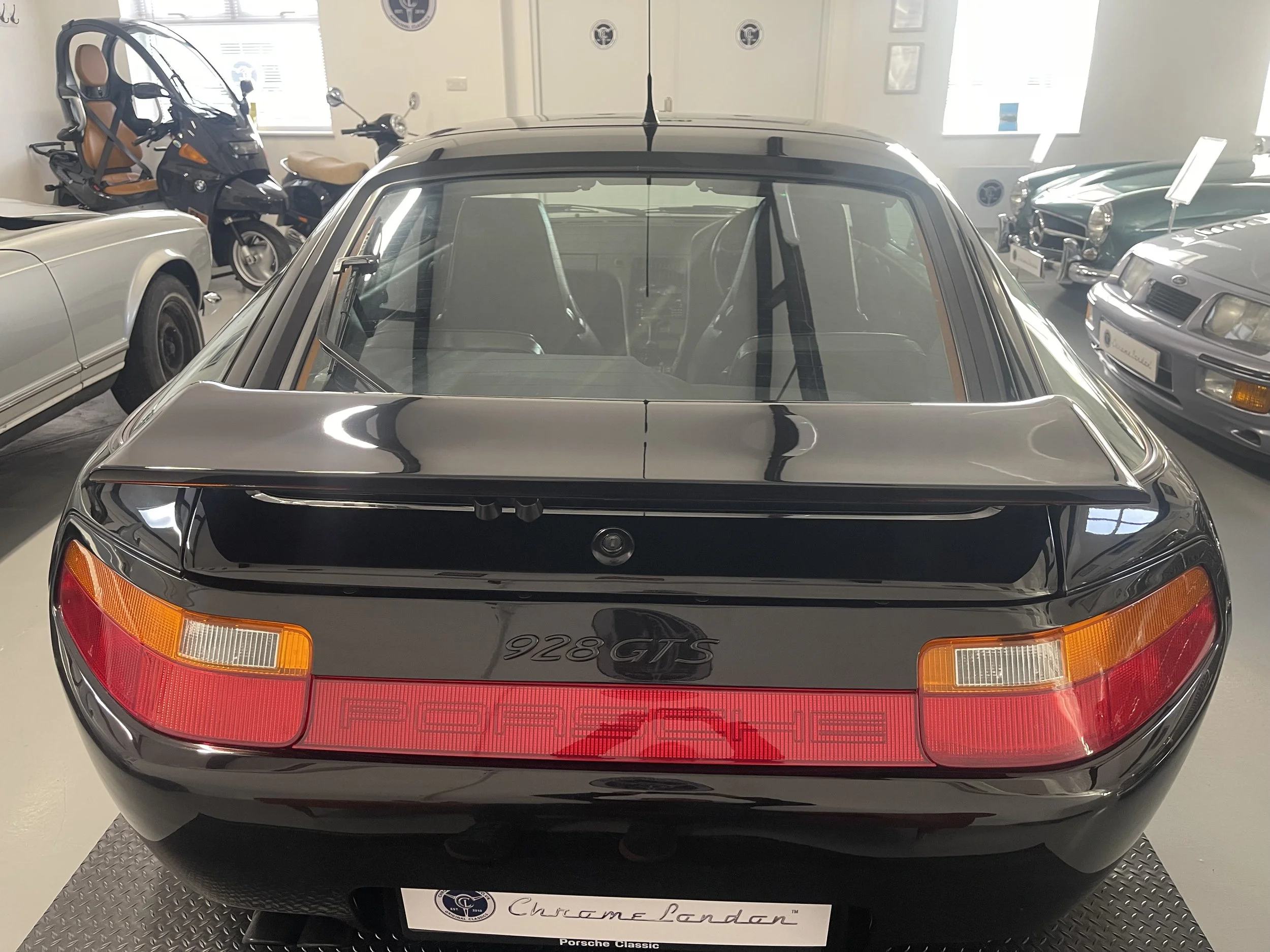 porsche 928 gts in black shown here in a showroom