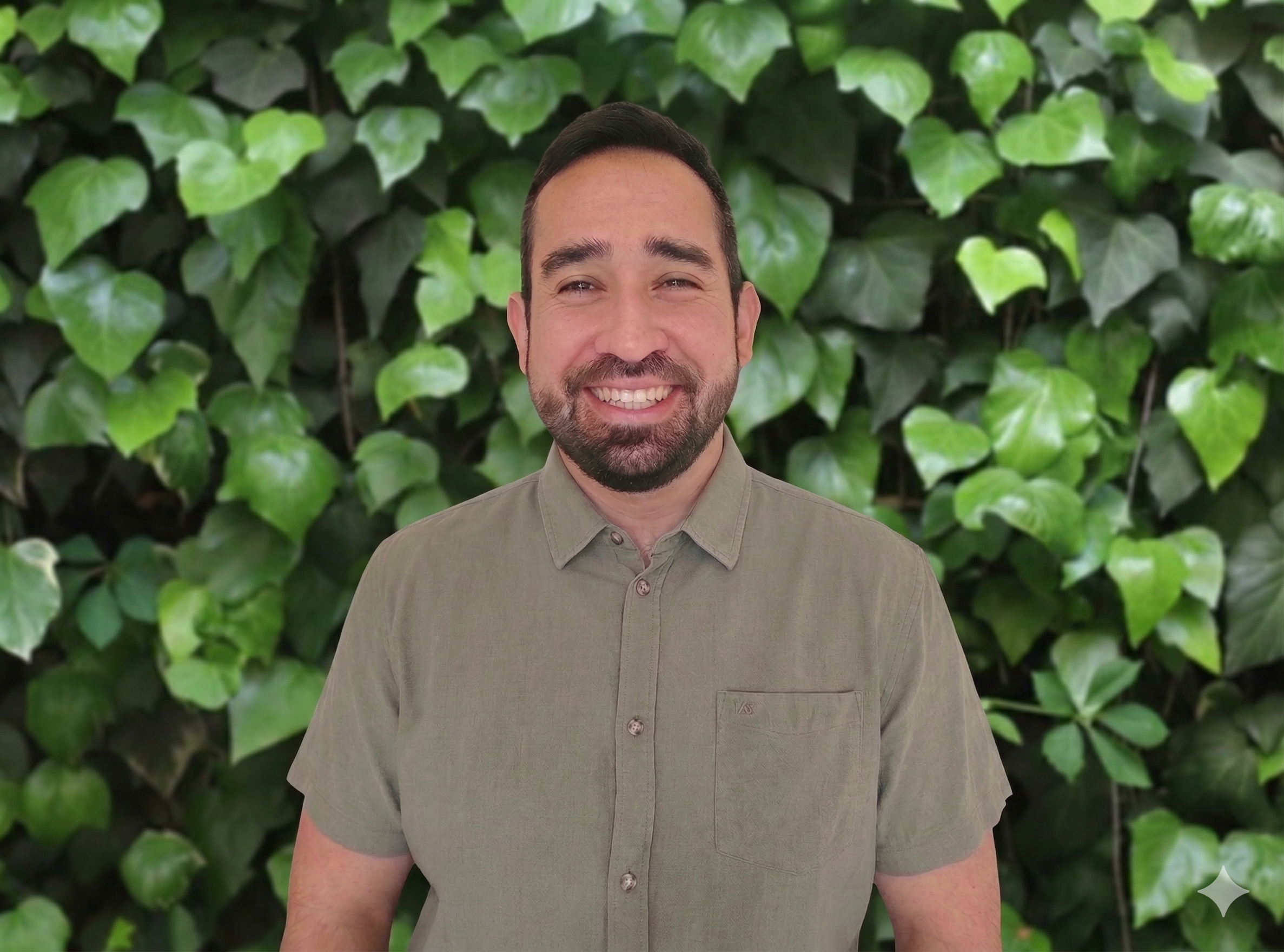 Silueta negra de una persona frente a un fondo lleno de hojas verdes.