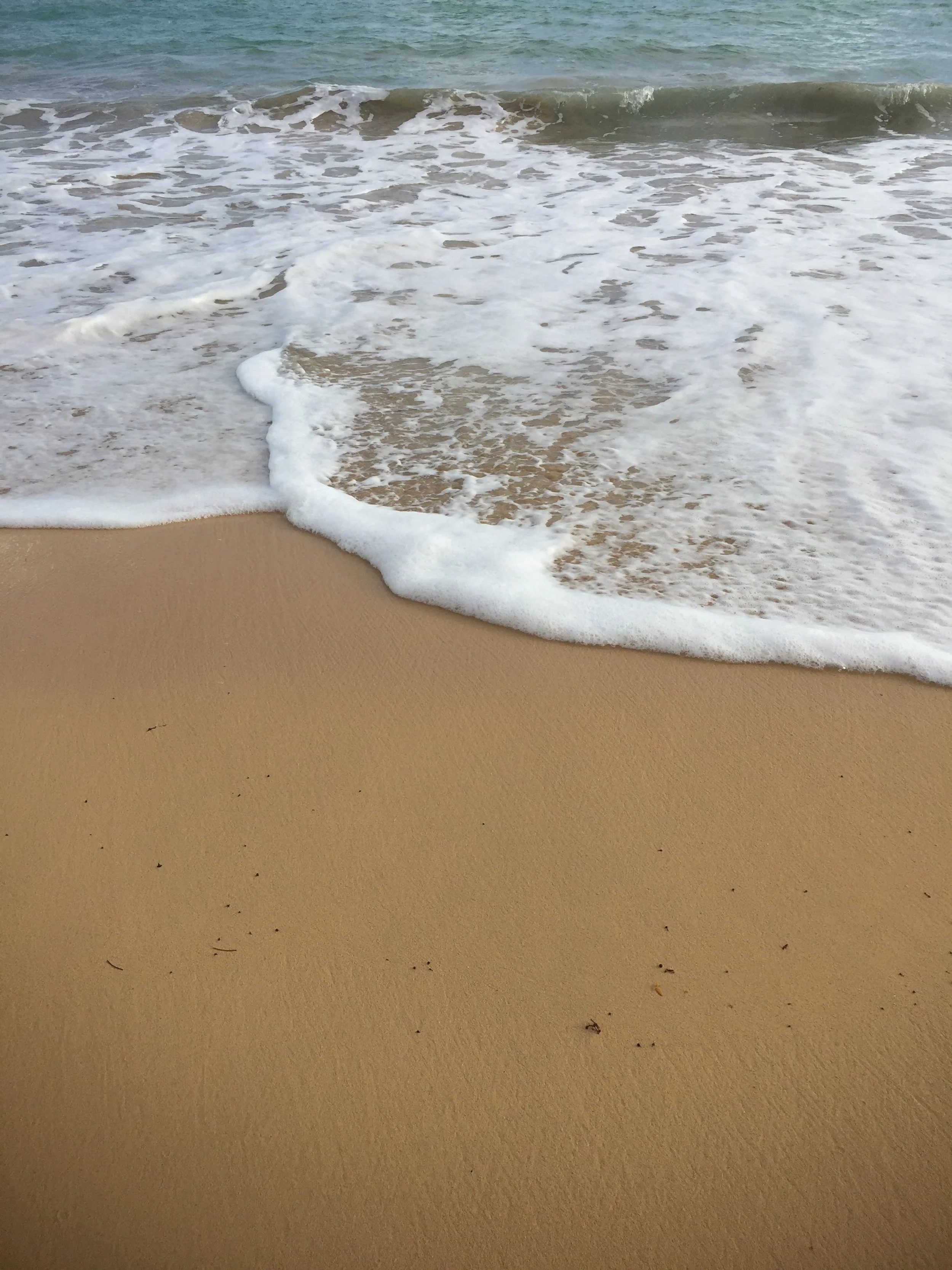 Ocean waves washing onto a sandy beach.