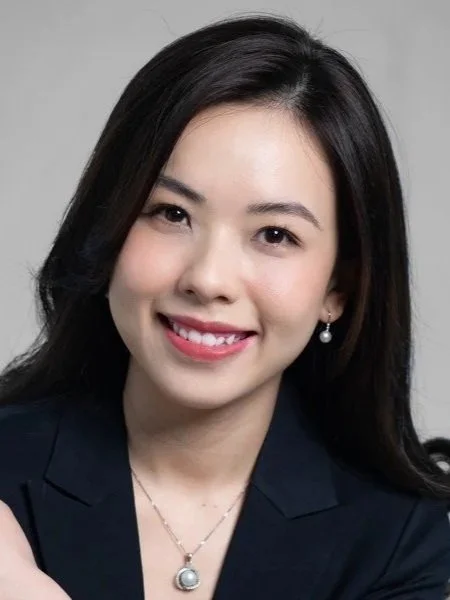 A man in a light gray suit speaking at the World Economic Forum, seated with a microphone in front of him and a badge around his neck.