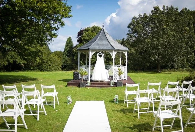 Outdoor wedding ceremony setup with wedding dress hung up at the Denham Grove Hotel
