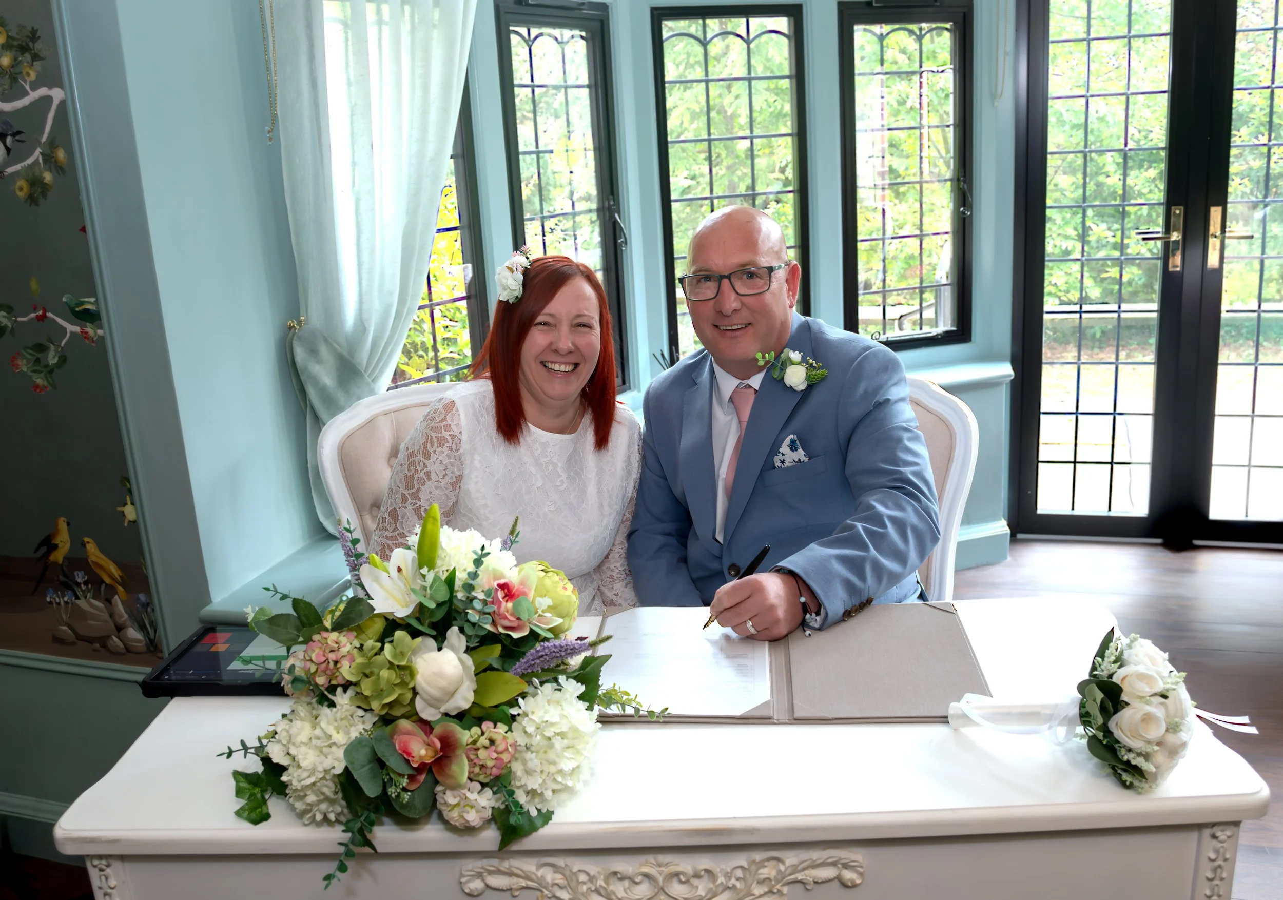 A bride and groom signing wedding register at Weybridge Register Office