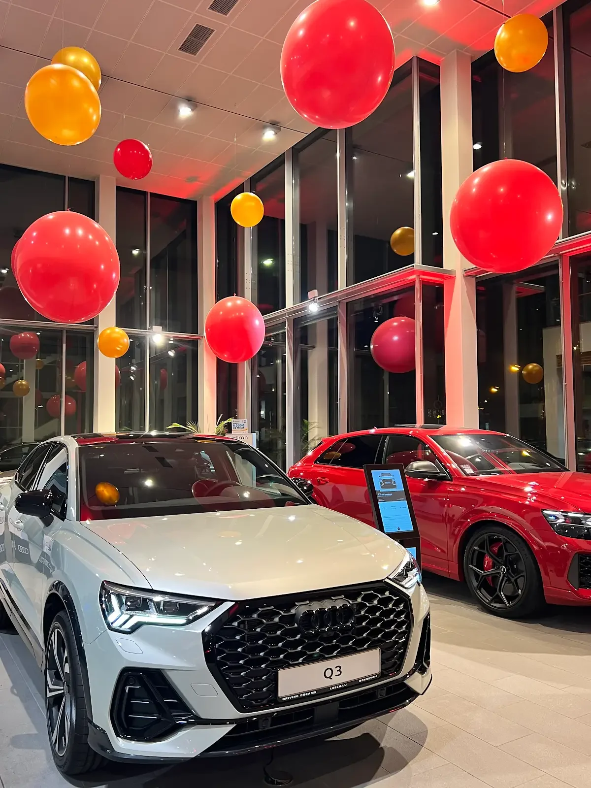 Decorative balloon sculptures of a pink bear with a red bow tie and a blue bear with a red bow tie, each holding a balloon bouquet.