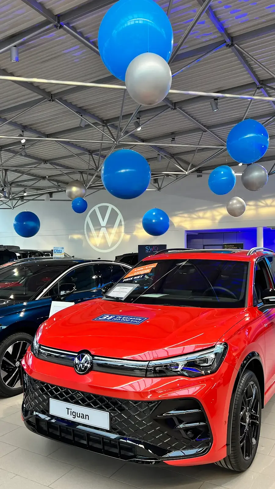 A decorative arrangement of plush teddy bears, white and beige balloons, and a small stuffed unicorn, creating a soft, cozy scene.